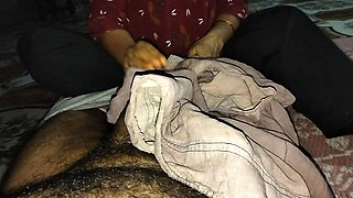 A desi wife massaging her husband's member with oil using her soft hands at night.